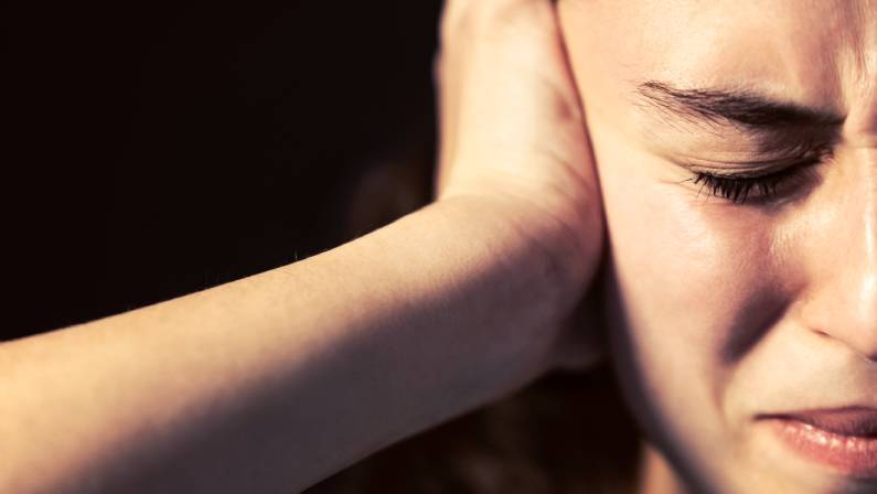 Photo of a young woman close-up with migraine