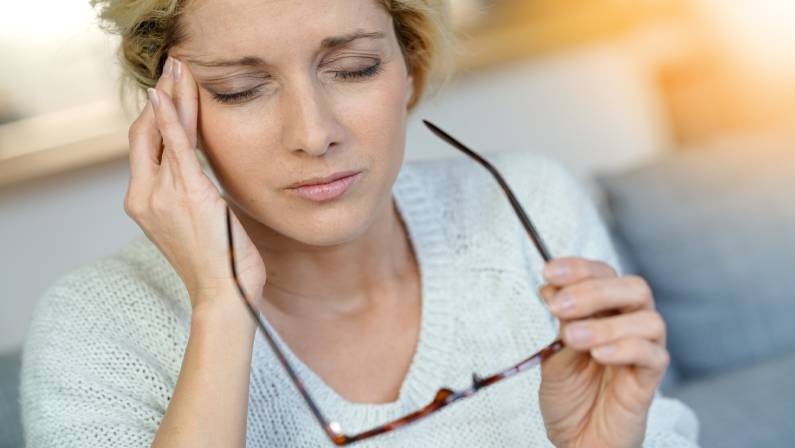 middle-aged blond woman having a migraine